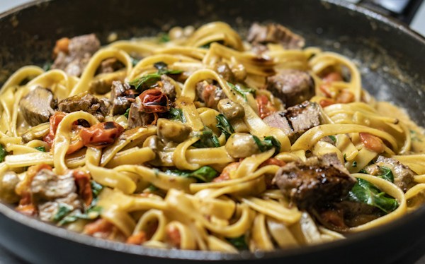 A plate of pasta with mushrooms and vegetables